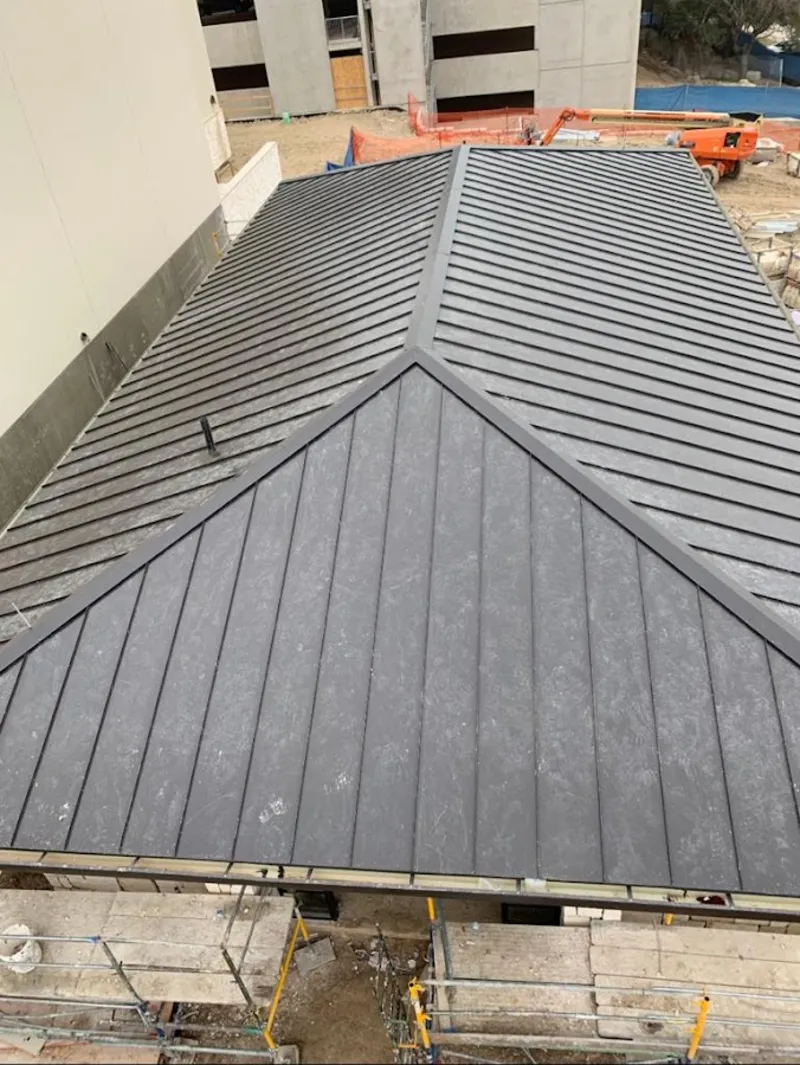 Commercial metal roof construction with crane equipment in Eagle Mountain